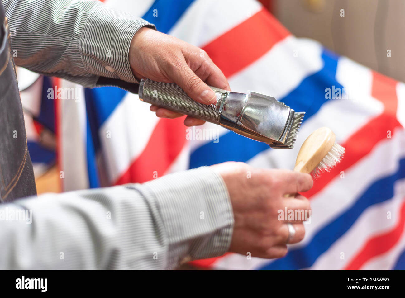 Barber cleaning electric hair clipper at barber shop Stock Photo Alamy