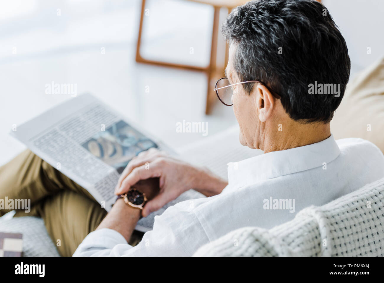 selective focus of senior man looking at watch at home Stock Photo