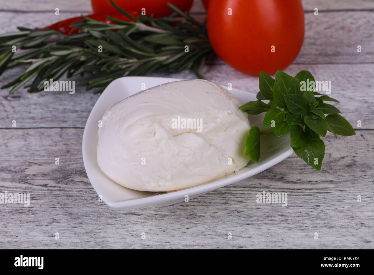 Italian Mozzarella cheese ball served basil and tomatoes Stock Photo