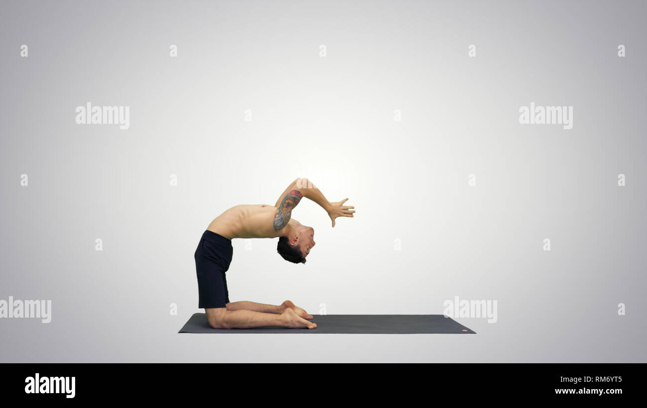 Yogi doing camel yoga pose on gradient background. Stock Photo