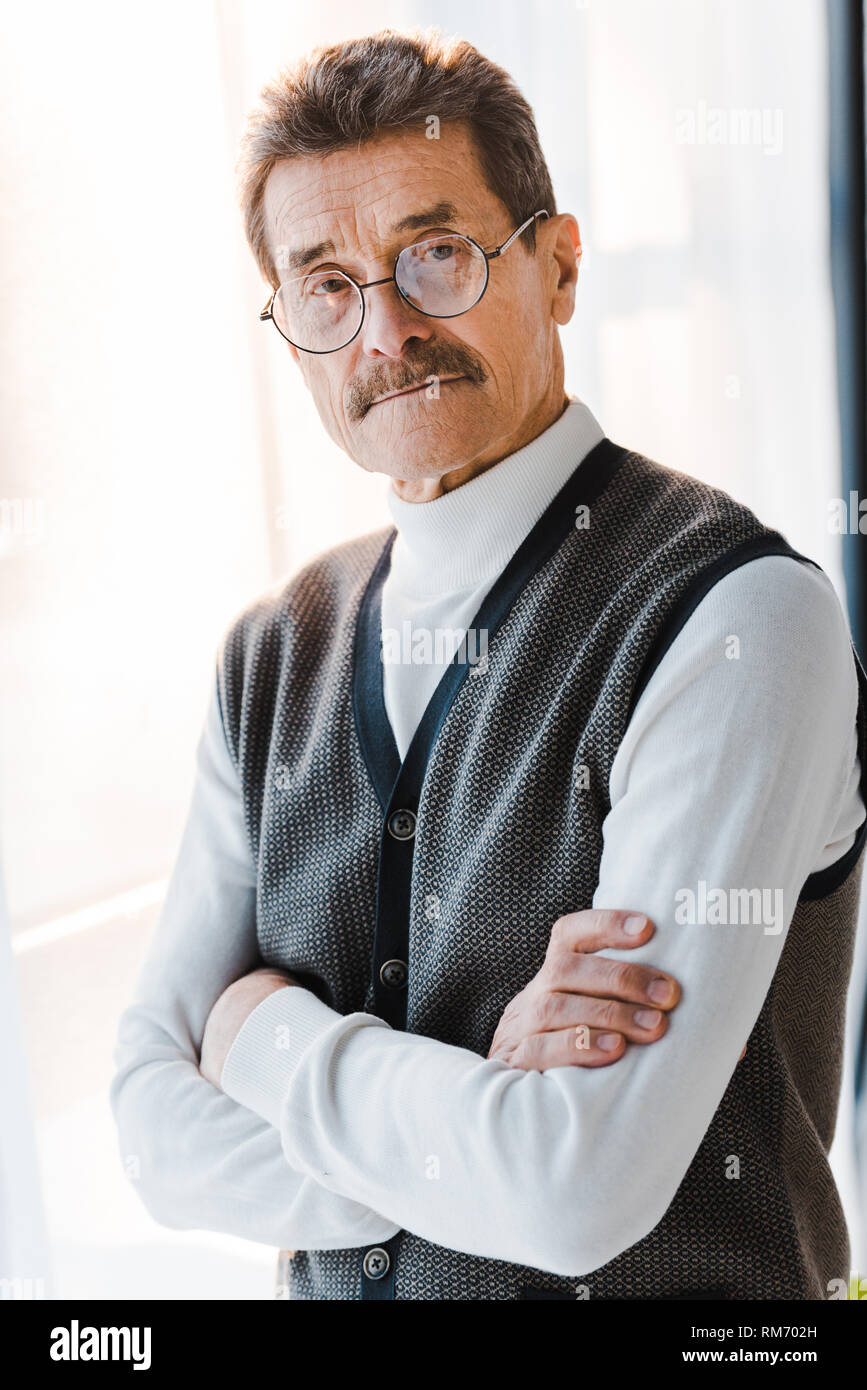 senior man with grey hair standing with crossed arms at home Stock ...