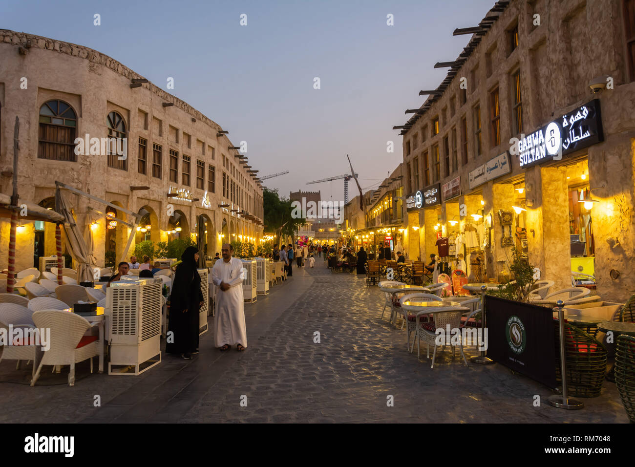 Doha, Qatar - November 3, 2016. Street view in Souq Waqif market in Doha, with historic buildings, commercial properties and people, at night. Stock Photo