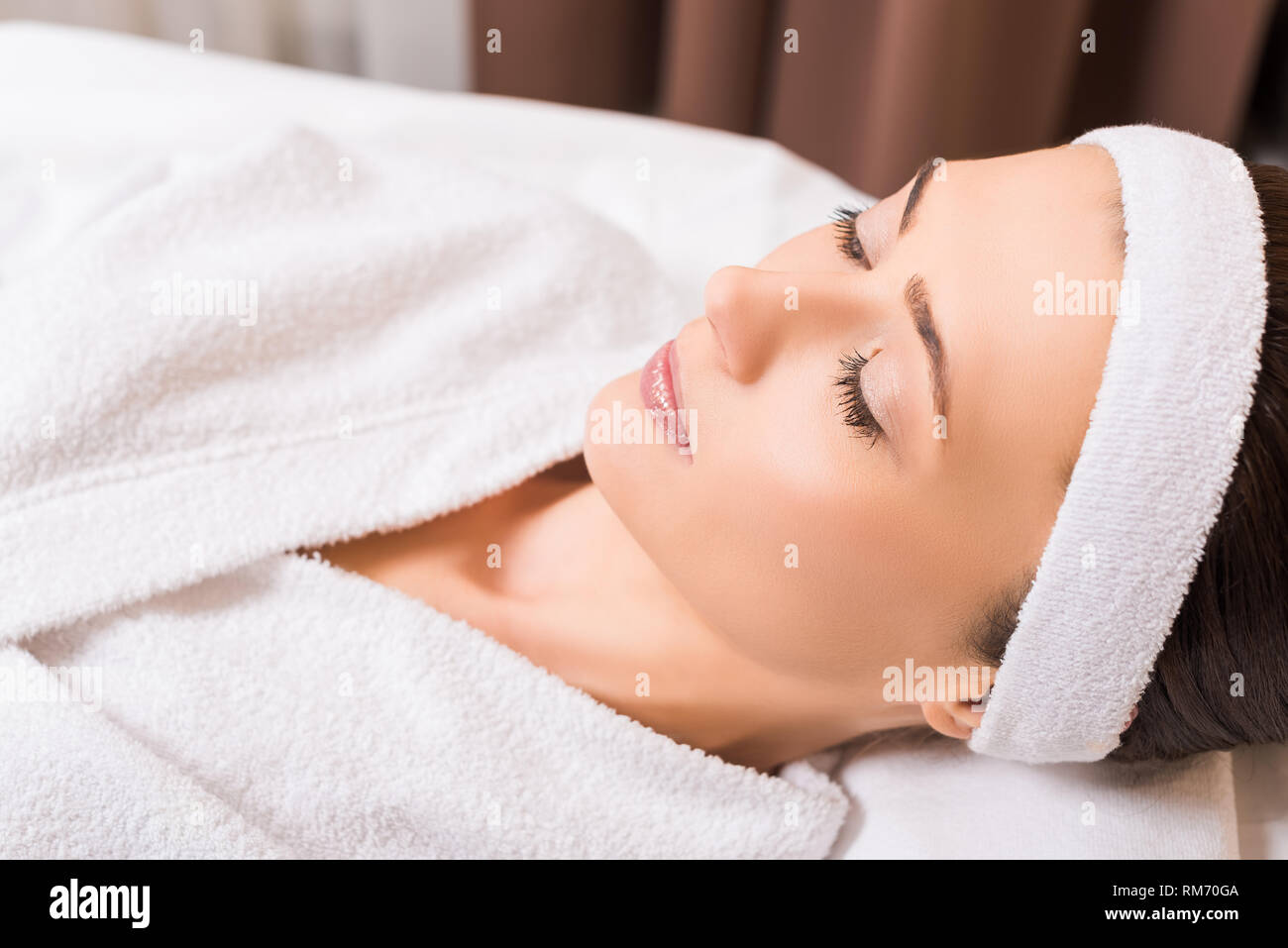 woman lying in white bathrobe and closed eyes at beauty salon Stock ...