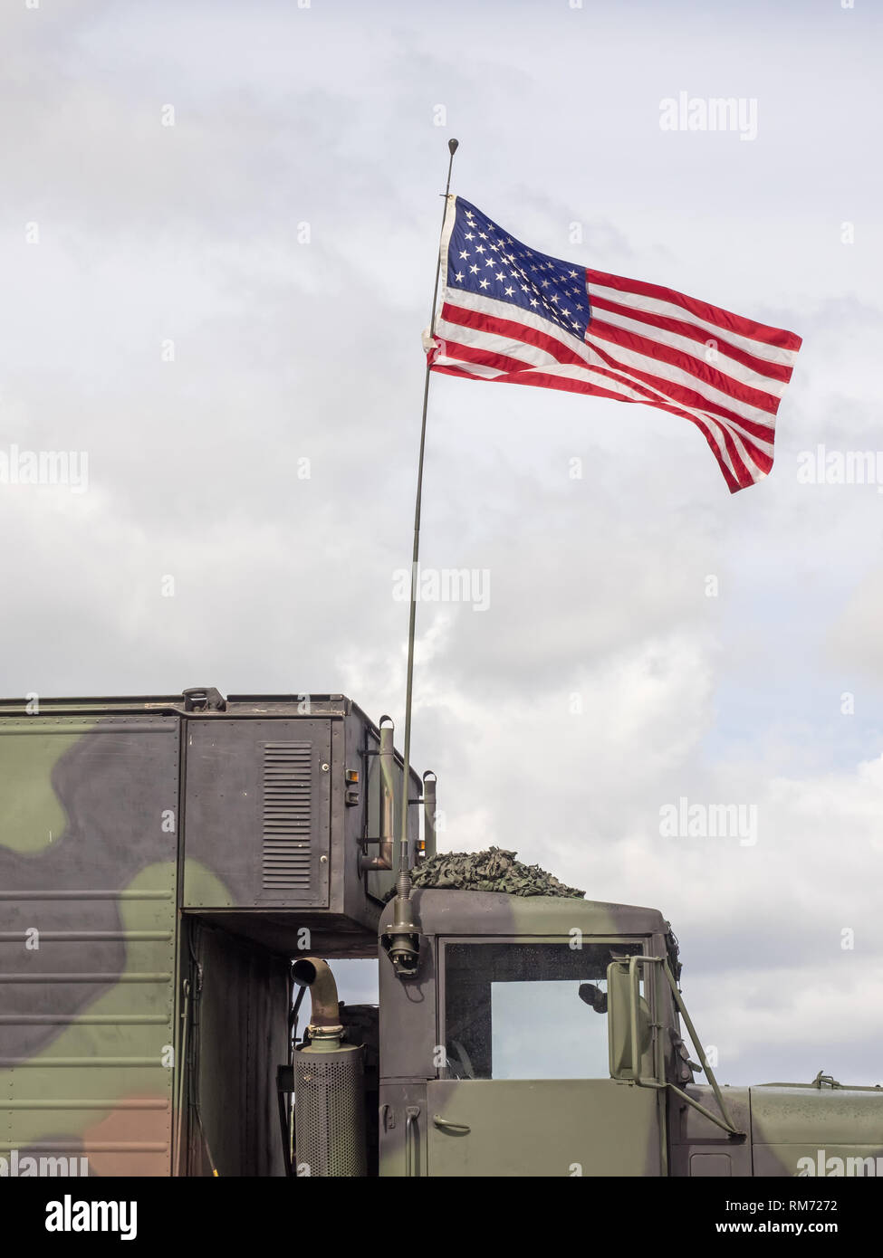 US flag waves at a military vehicle Stock Photo
