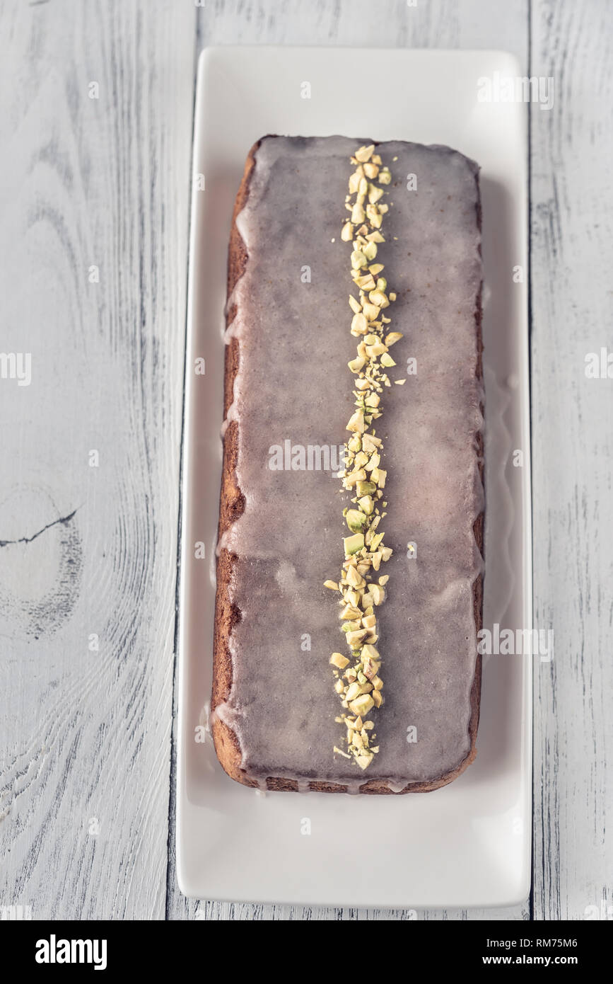 Lemon cake with icing decorated with pistachios: top view Stock Photo