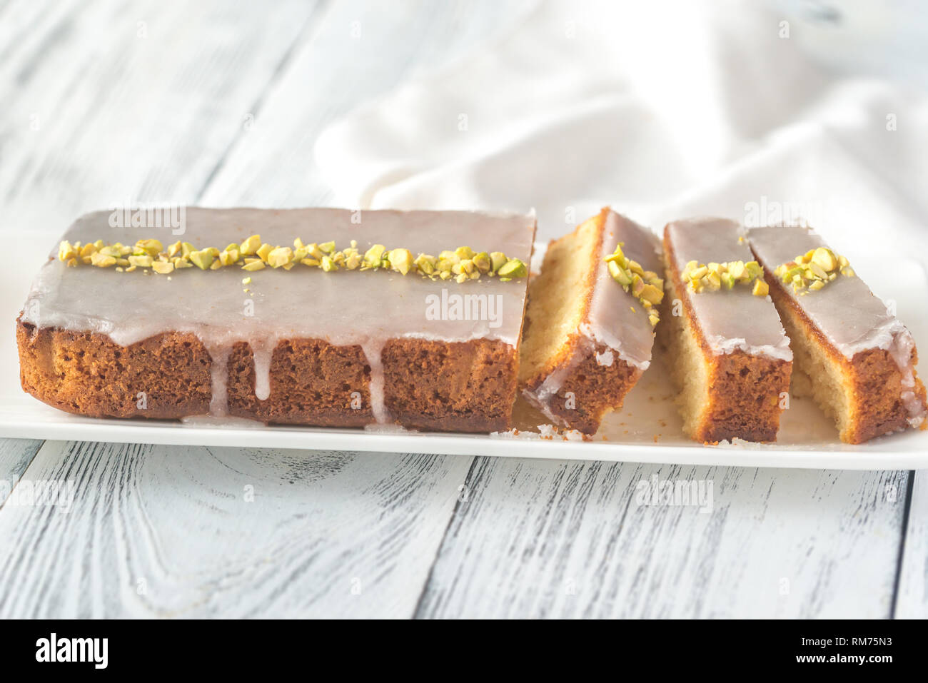 Lemon cake with icing decorated with pistachios: top view Stock Photo
