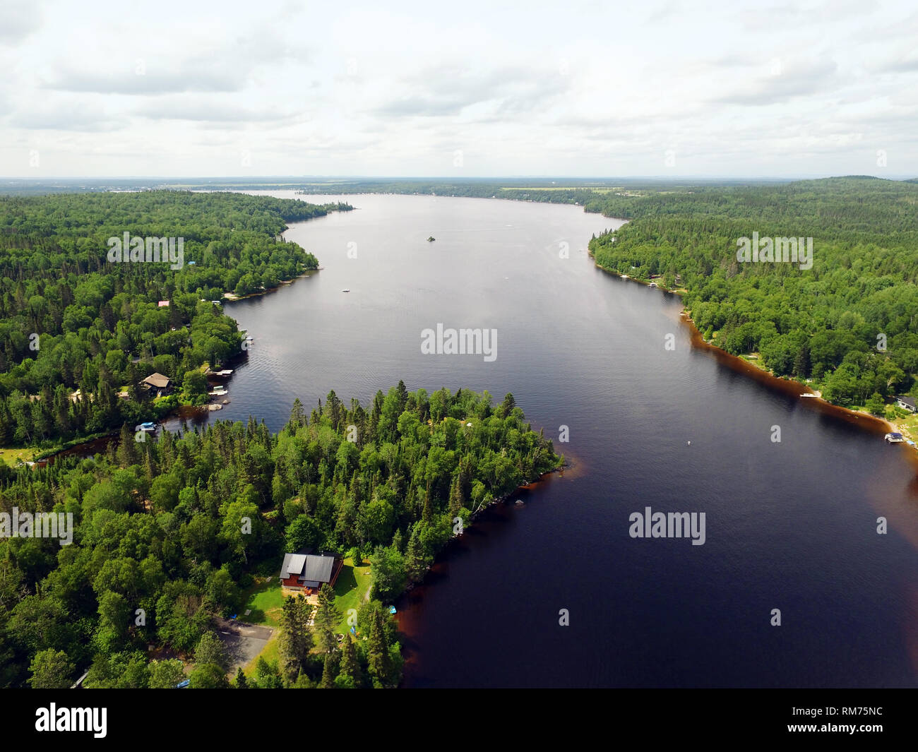 Aerial view of forest and lake with cottages and boats Stock Photo