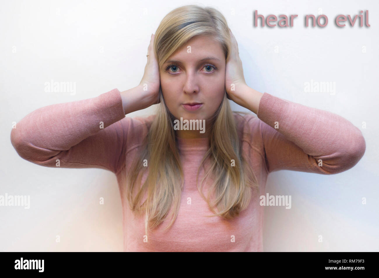 young woman showing the proverbial principle of three wise monkeys - hear no evil Stock Photo