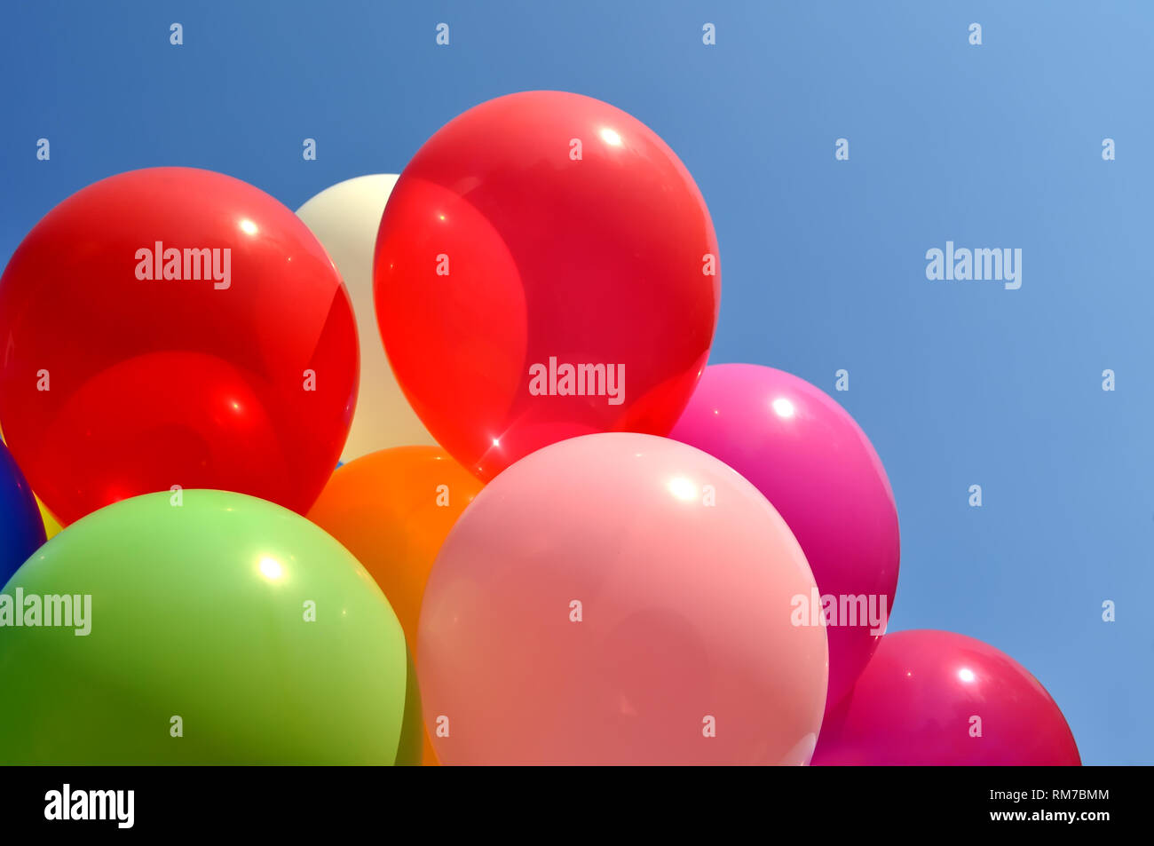 multicolored balloons in the city festival on blue sky background Stock Photo