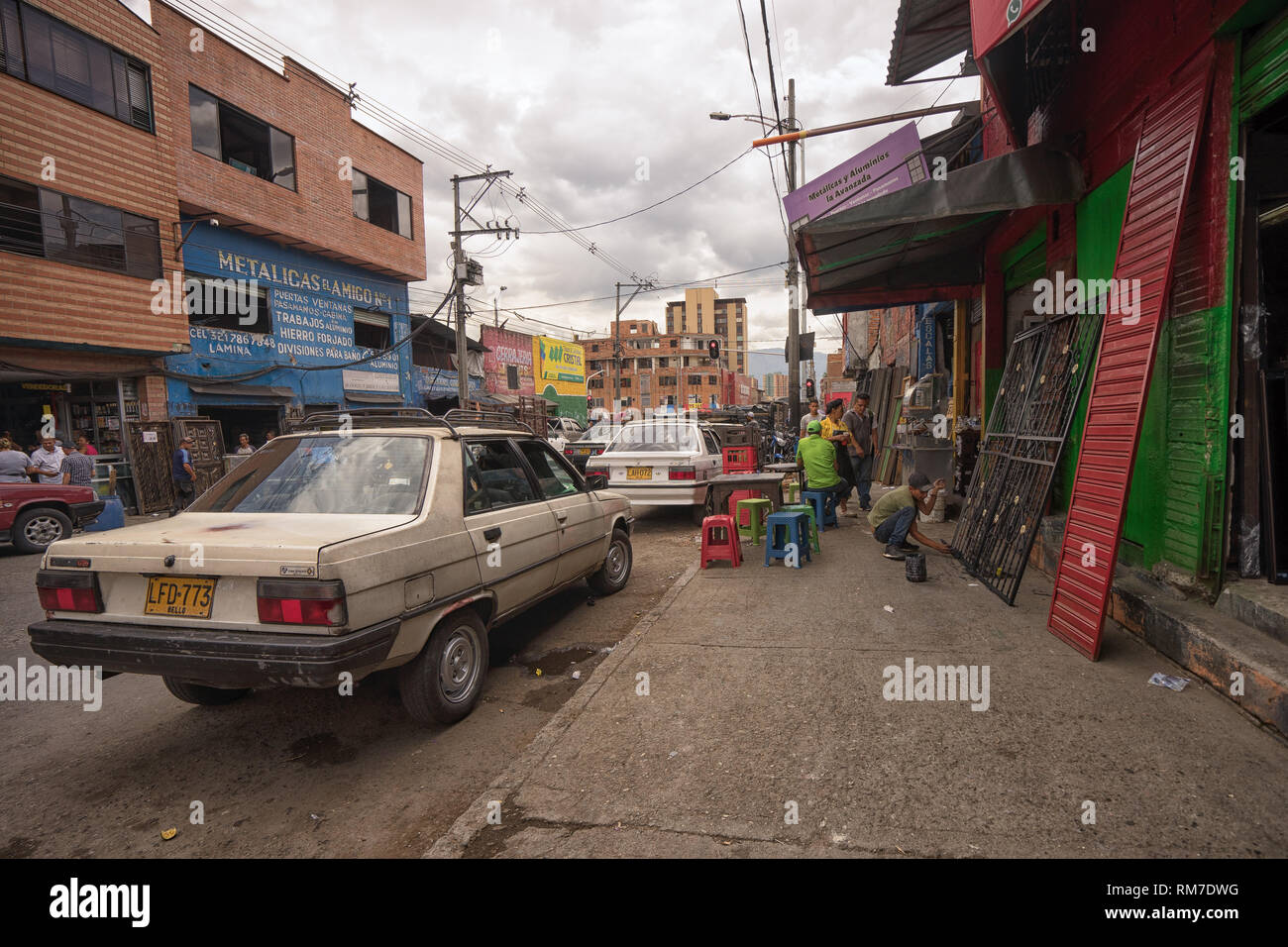 Medellin, Colombia - July 26, 2018: cars parked in front of a welding shop Stock Photo
