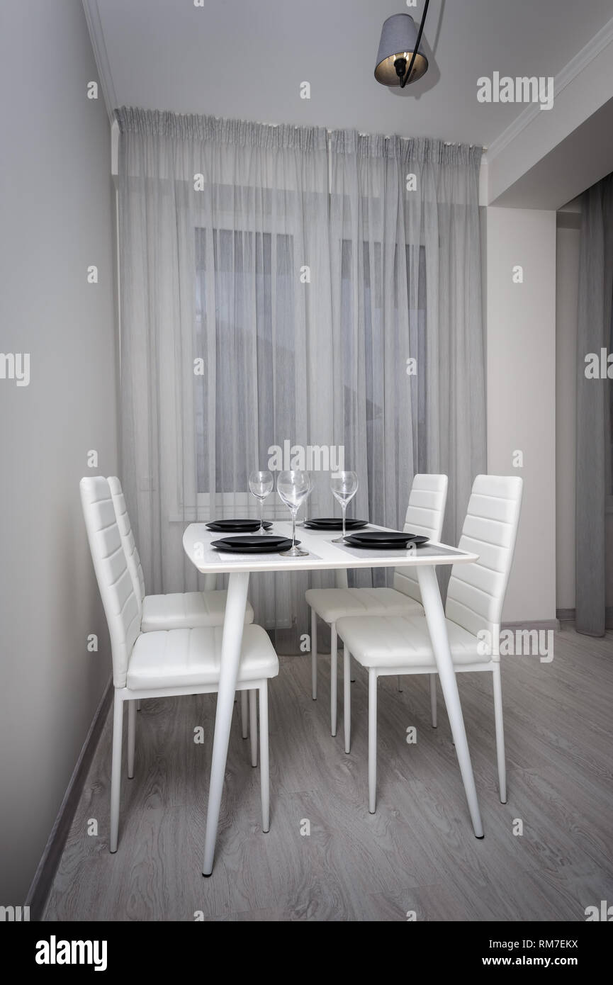 Modern white and gray living room with dining table Stock Photo - Alamy