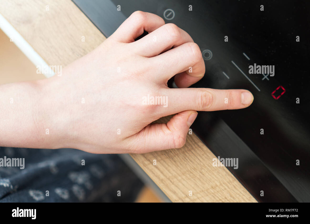Dangerous situation in the kitchen. Child playing with electric glassceramic cooktop stove