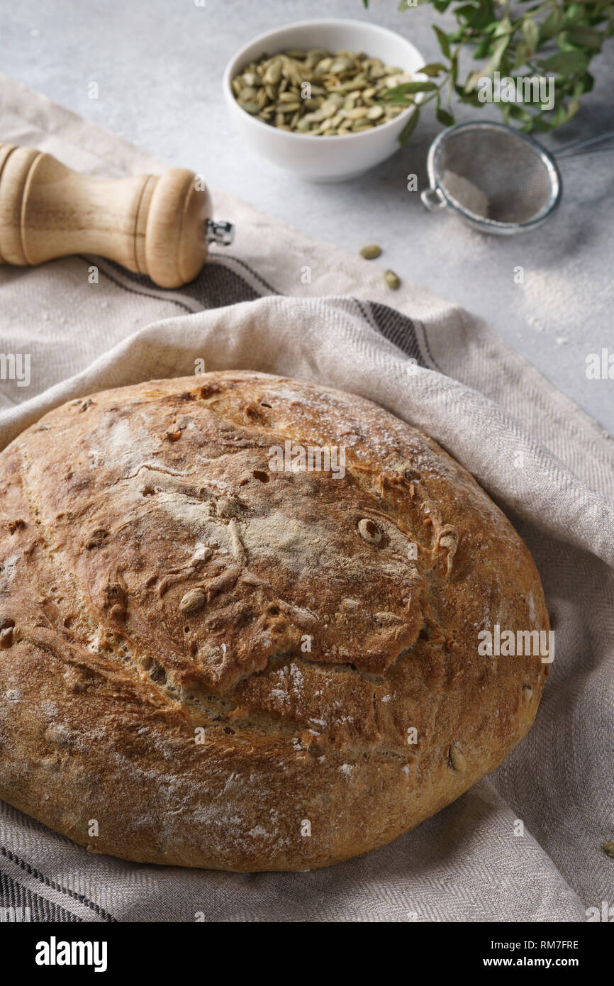 Homemade whole grain bread with seeds on a gray background, home bakery concept. Stock Photo
