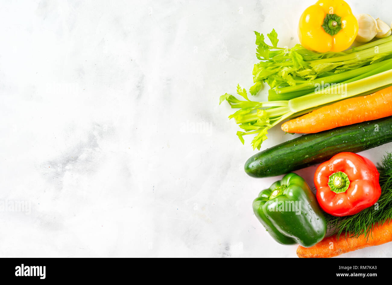 White stone background with a border of fresh vegetables. Top view. Stock Photo