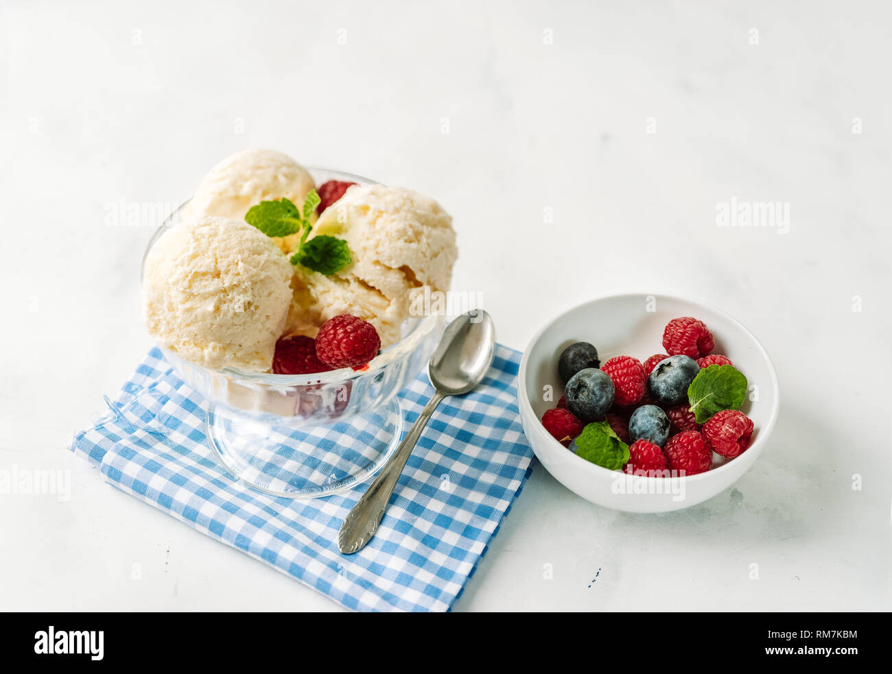 Vanilla ice cream in a glass cup with berries on white background Stock Photo