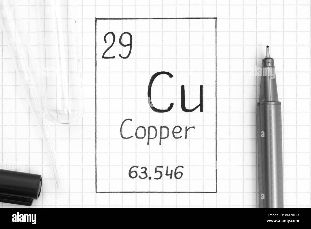 The Periodic table of elements. Handwriting chemical element Copper Cu with black pen, test tube and pipette. Close-up. Stock Photo
