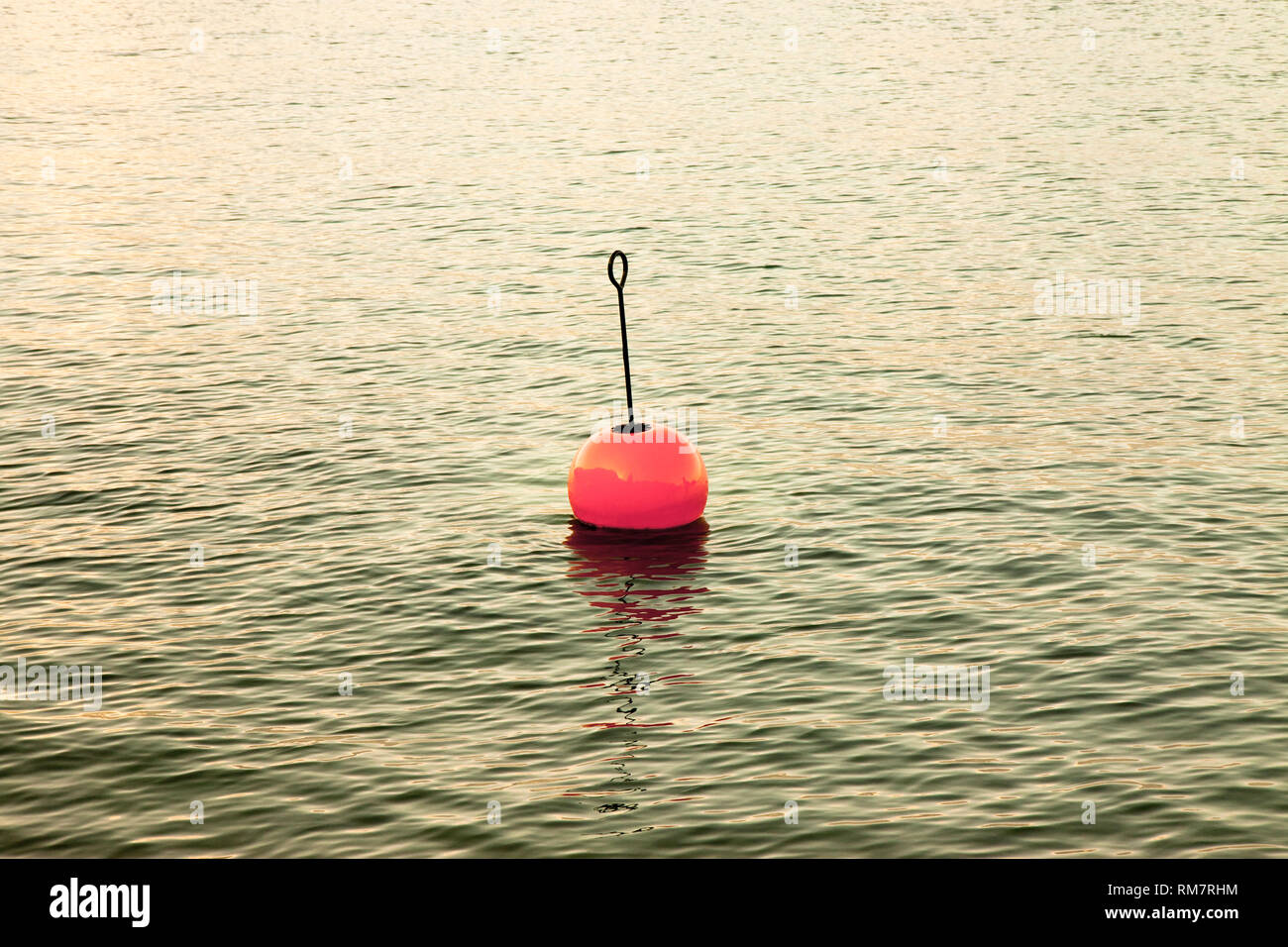 Red bouy on a calm lake - toned image Stock Photo