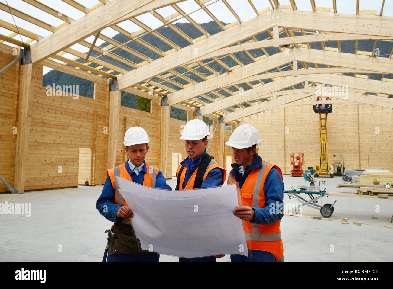 Three builders discuss the plan for a major construction job Stock Photo