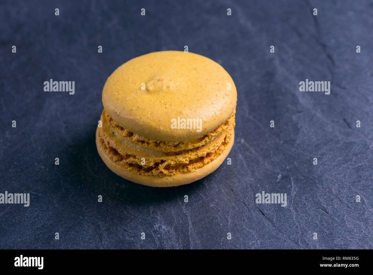 Orange macaroni on a dark background. Sweets were invented in France. Photos of food Stock Photo