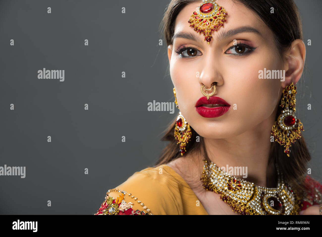 attractive indian woman posing in traditional bindi, isolated on grey Stock Photo