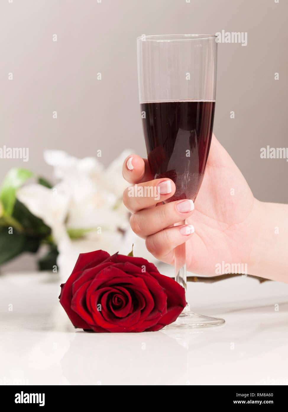 Beautiful woman hand with polished nais holding glass of red wine Stock Photo