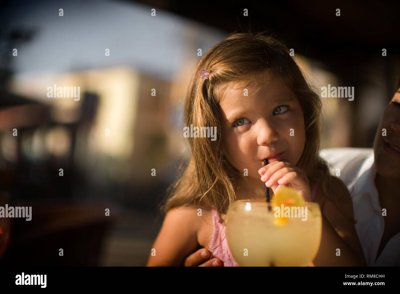 View of a small girl drinking lemonade. Stock Photo