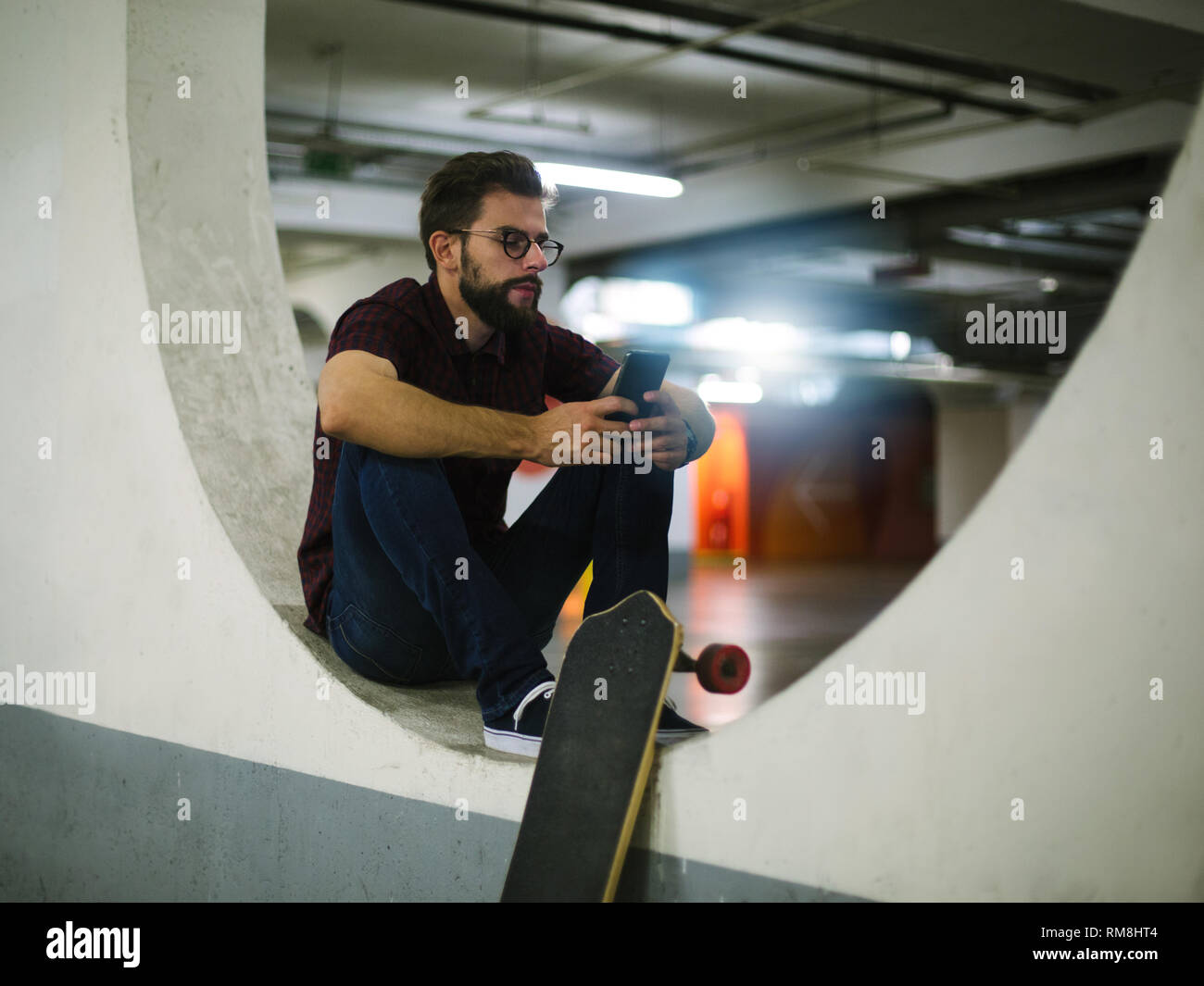 Hipster skater using smart phone in underground Stock Photo