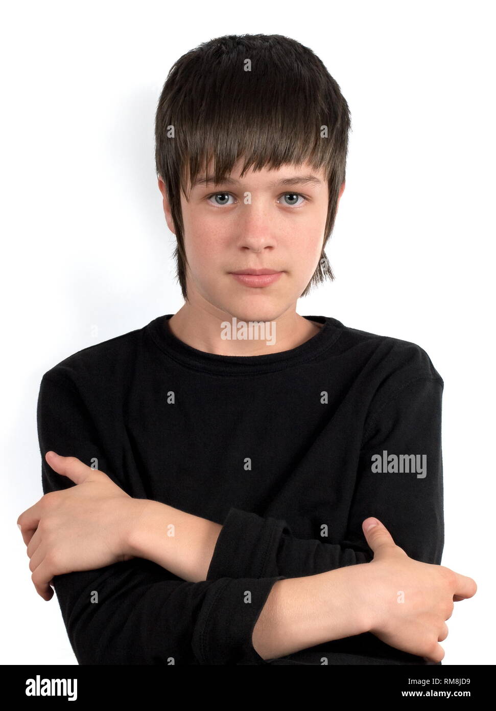 Portrait of serious teenager in black shirt with crossed hands on the chest Stock Photo