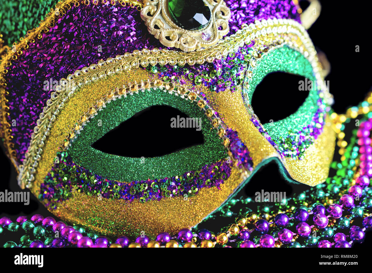 Jester mask close up with beads on a black background. Stock Photo