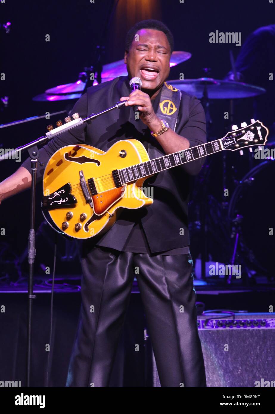 Guitarist Benson is shown performing on stage during a "live