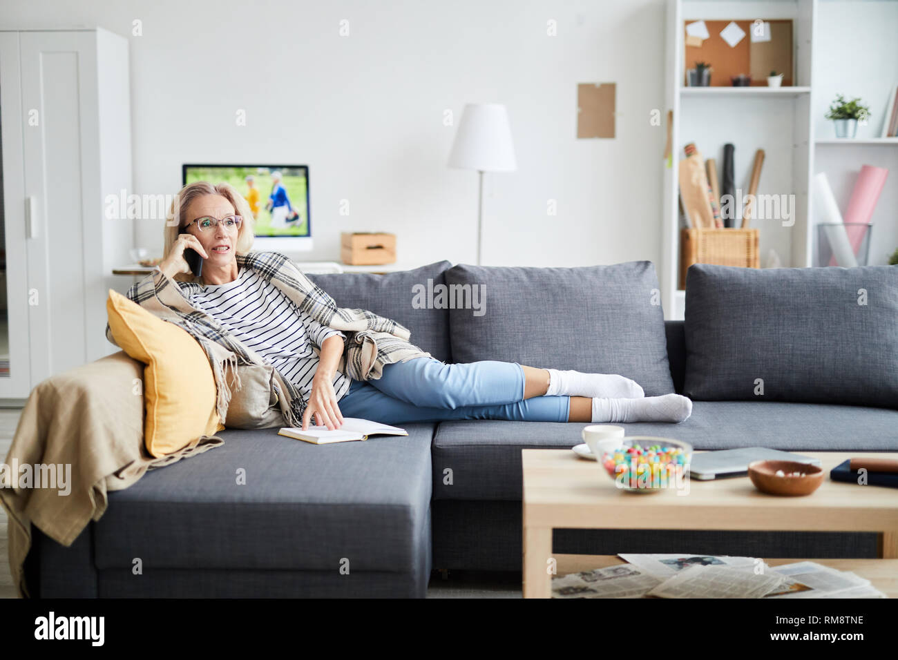 Mature Woman Speaking by Phone at Home Stock Photo