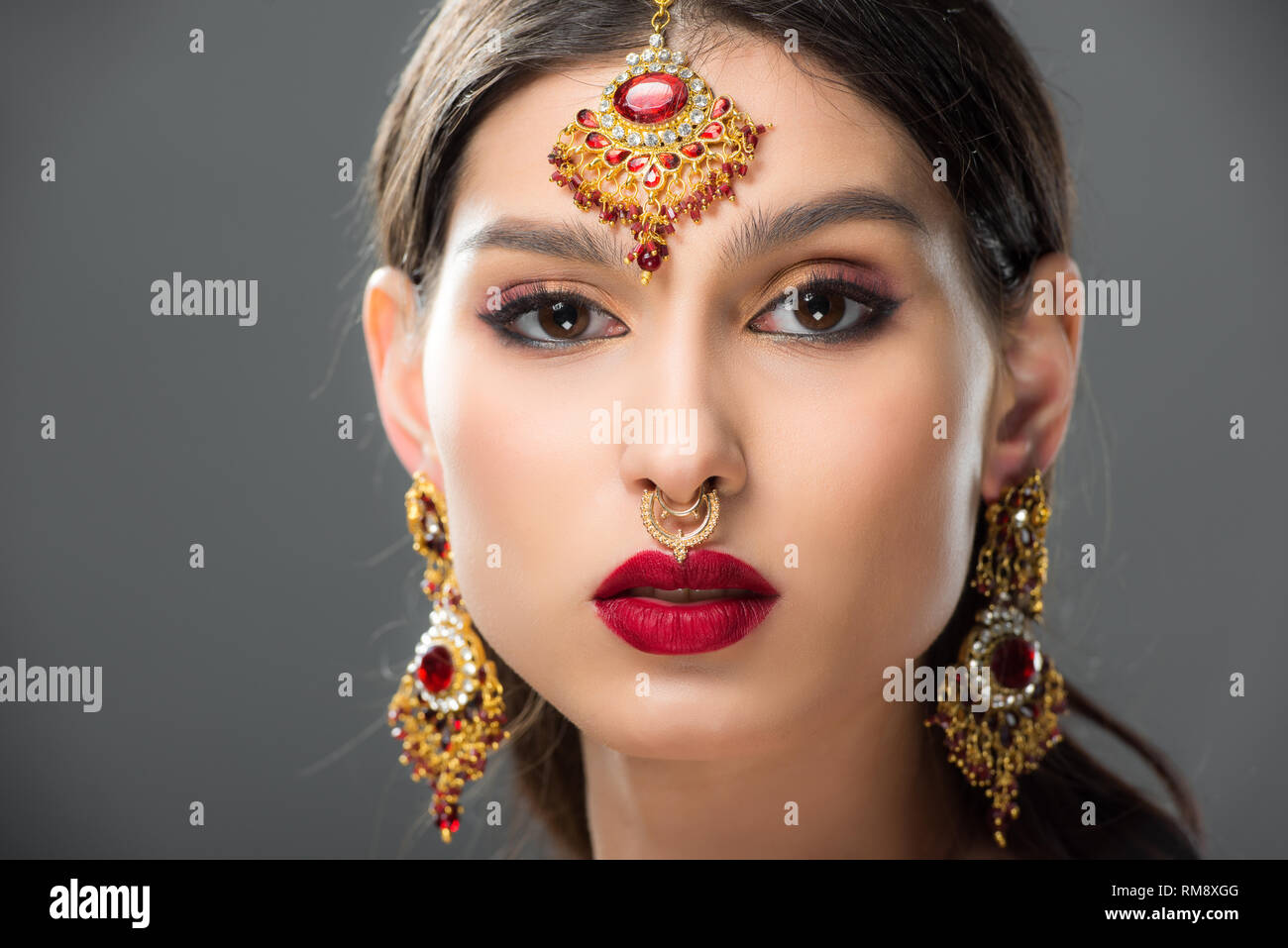 attractive indian woman in traditional accessories, isolated on grey