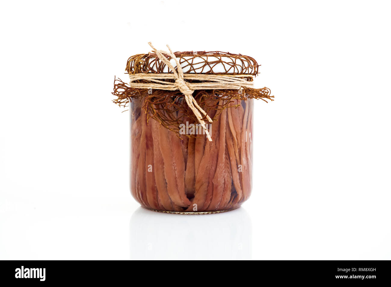 Handmade anchovy fillets in olive oil in a transparent glass jar. Full jar of salty anchovies