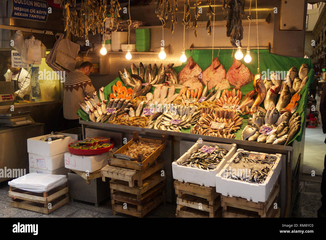 Istanbul, Turkey - January 06 2012: A Fishmonger working at his booth in he fish market near Galata Bridge called Karakoy Balik Pasari with many fish  Stock Photo