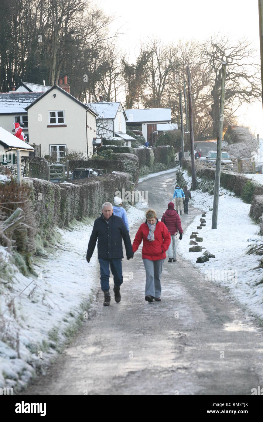 People walking in the Cheshire countryside in snow during winter near Burwardsley and the Sandstone trail in Bickerton hills Stock Photo