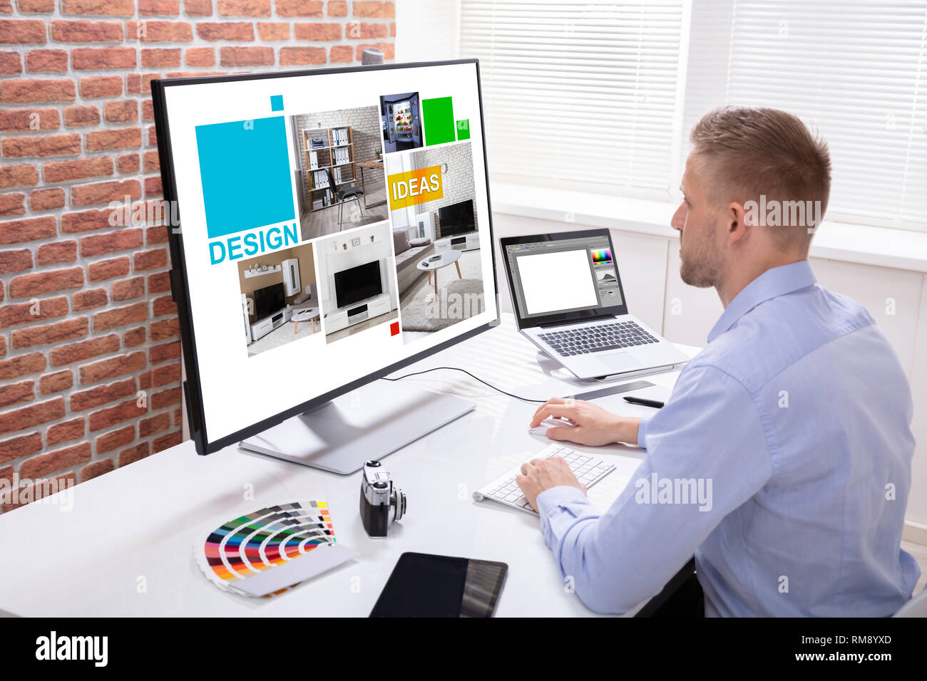 Male Designer Using Graphic Tablet While Working On Computer Stock Photo