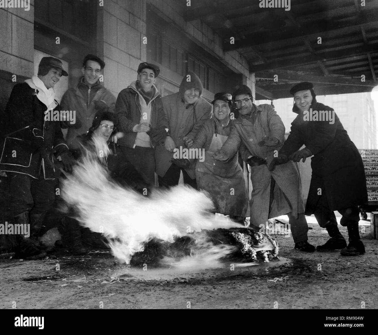 Loading dock workers keep warm with a fire during a cold winter day on Lower Wacker Drive in Chicago, ca.1953. Stock Photo