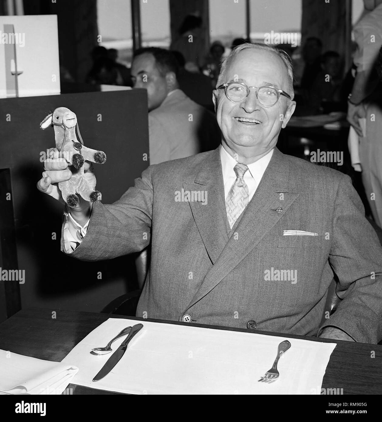 Former President Harry S. Truman displays a toy donkey he purchased for his grandchild during a visit to Chicago in July 1957. Stock Photo