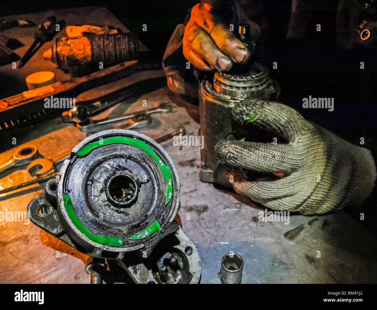 Locksmith repairs car parts, oiled hands and gloves. Locksmith repairs car parts, oiled hands and gloves. Stock Photo