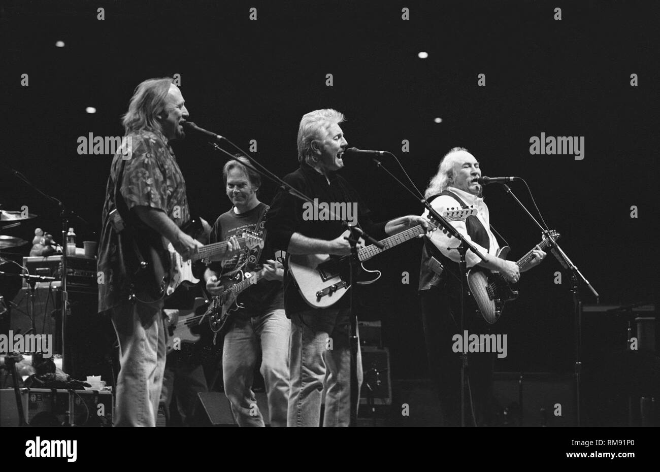 Stephen Stills, Graham Nash, Neil Young and David Crosby are shown performing on stage during a CSN&Y concert appearance. Stock Photo