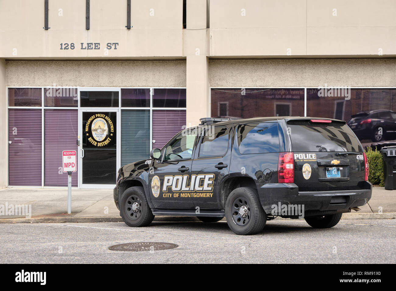 Black police or law enforcement SUV vehicle parked in front of a district or precinct headquarters building in Montgomery Alabama, USA. Stock Photo