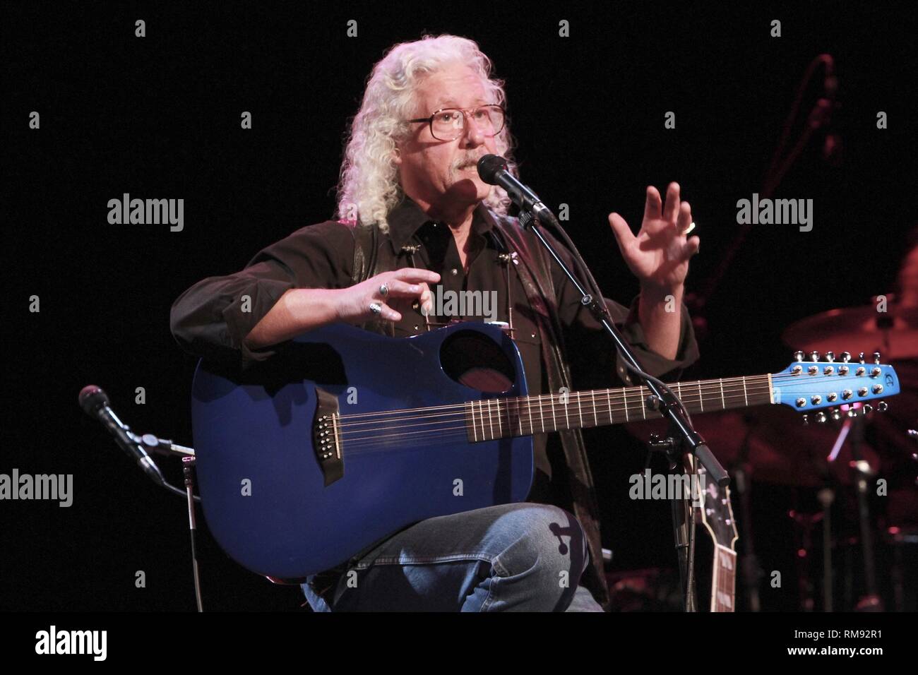 Singer, songwriter and guitarist Arlo Guthrie is shown performing on stage during a 'live' concert appearance. Stock Photo