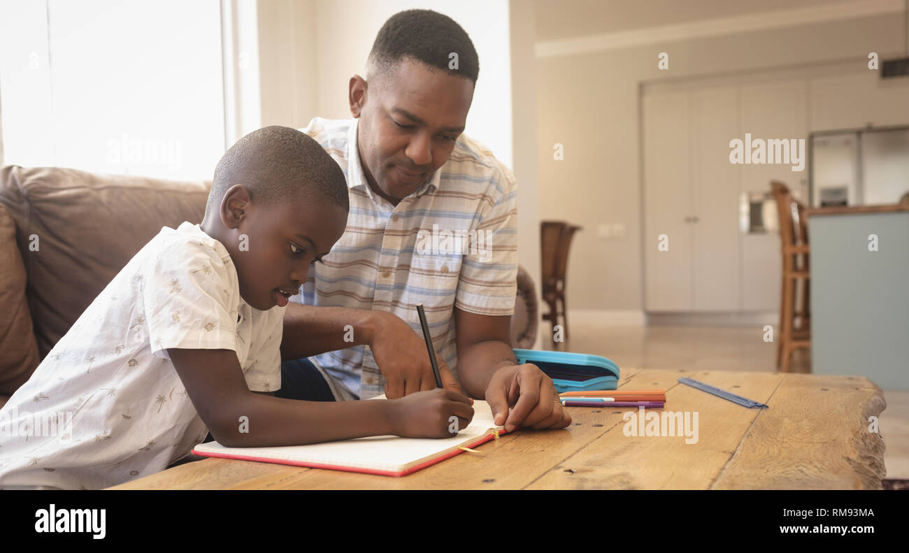 African American father helping his son with homework at table Stock ...