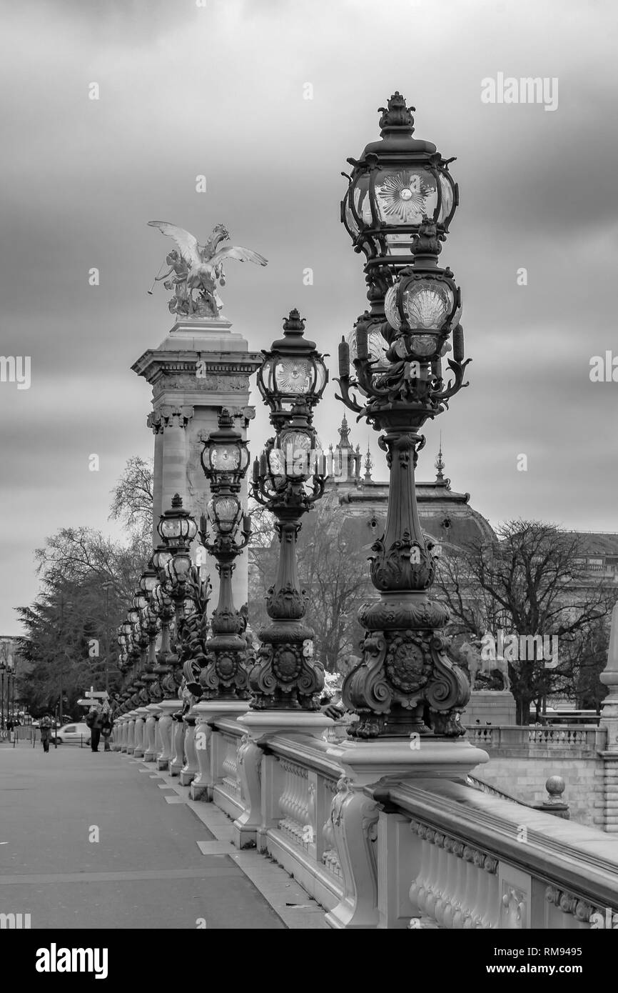 Moody cityscape with Pont Alexandre III bridge and Seine river and Eiffel Tower in Paris, France in black and white treatment Stock Photo
