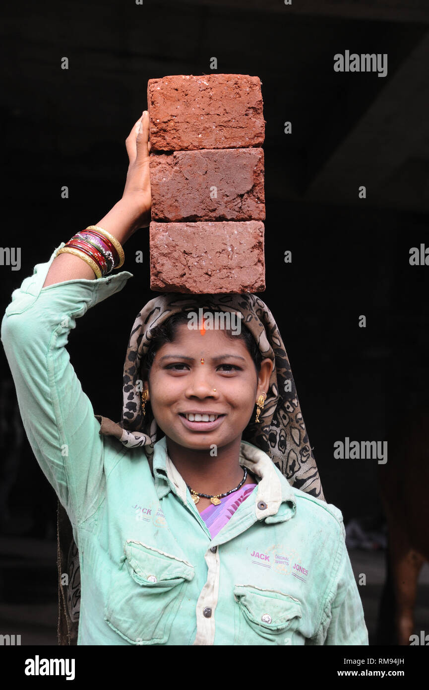 Woman carrying bricks for construction, Pune, Maharashtra, India, Asia Stock Photo