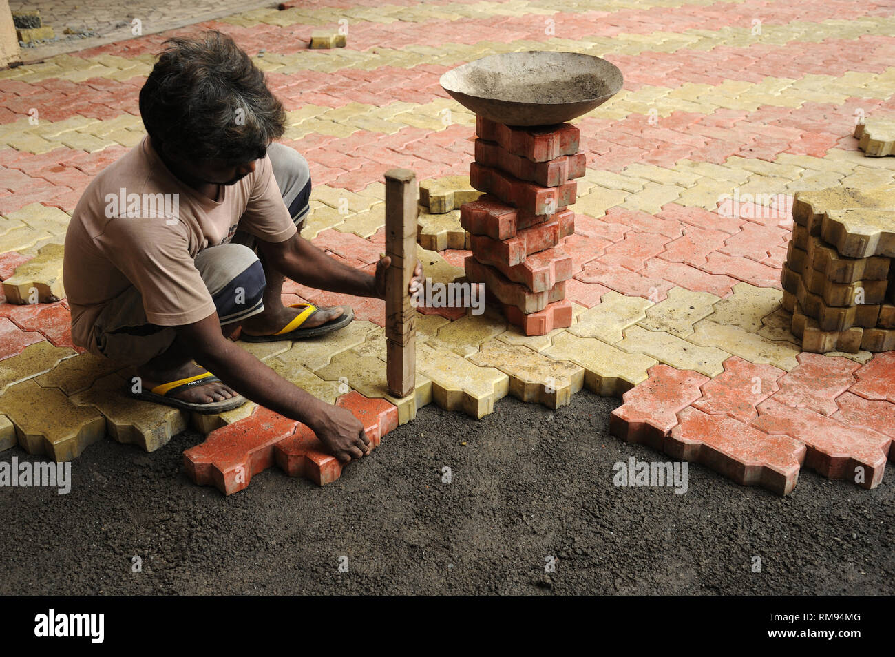 Worker laying interlocking concrete Paver block bricks, India, Asia Stock Photo