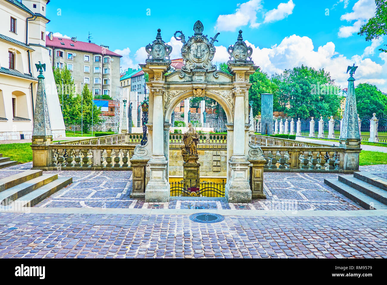 The courtyard of Church at Skalka with Well-fountain of St Stanislaus and the sculptural group of Altar of Three Millennia on background, Krakow, Pola Stock Photo