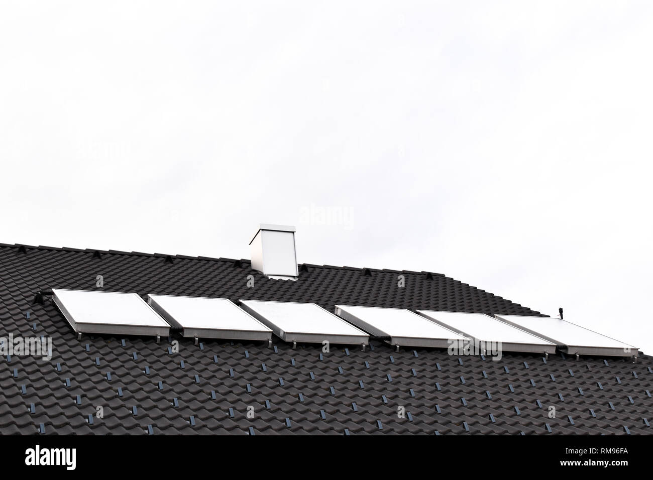 Hot water solar panels on house roof Stock Photo