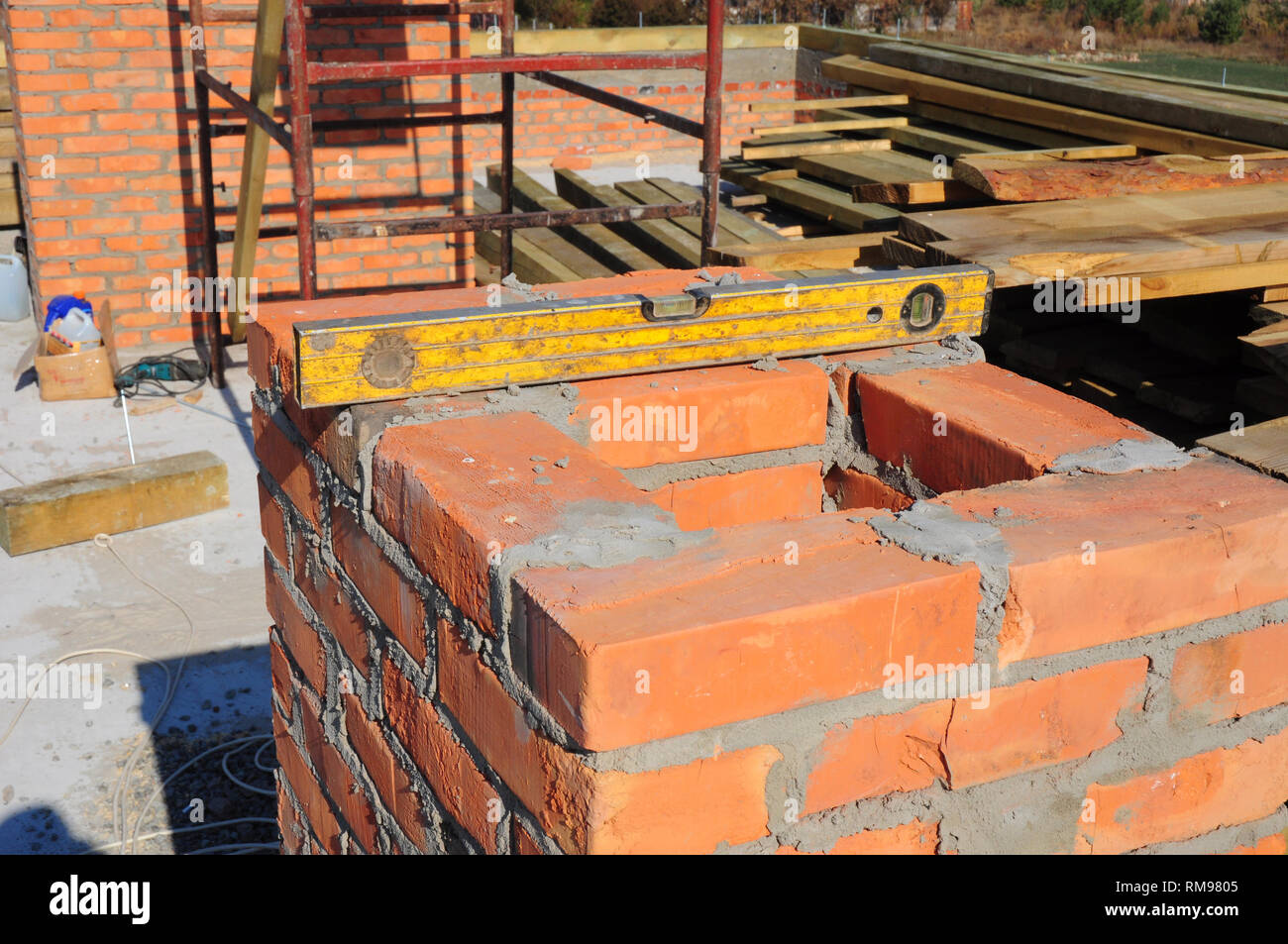Building brick chimney on new house construction. Stock Photo