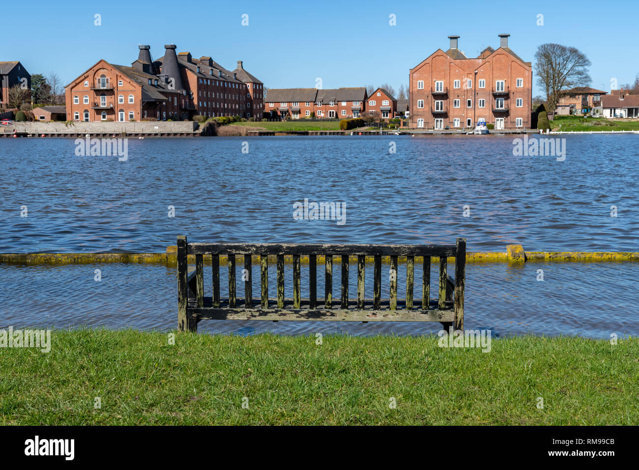 Oulton Broad, Suffolk, England, UK - April 05, 2018: Flooded bench on the shore of the Oulton Broad Stock Photo